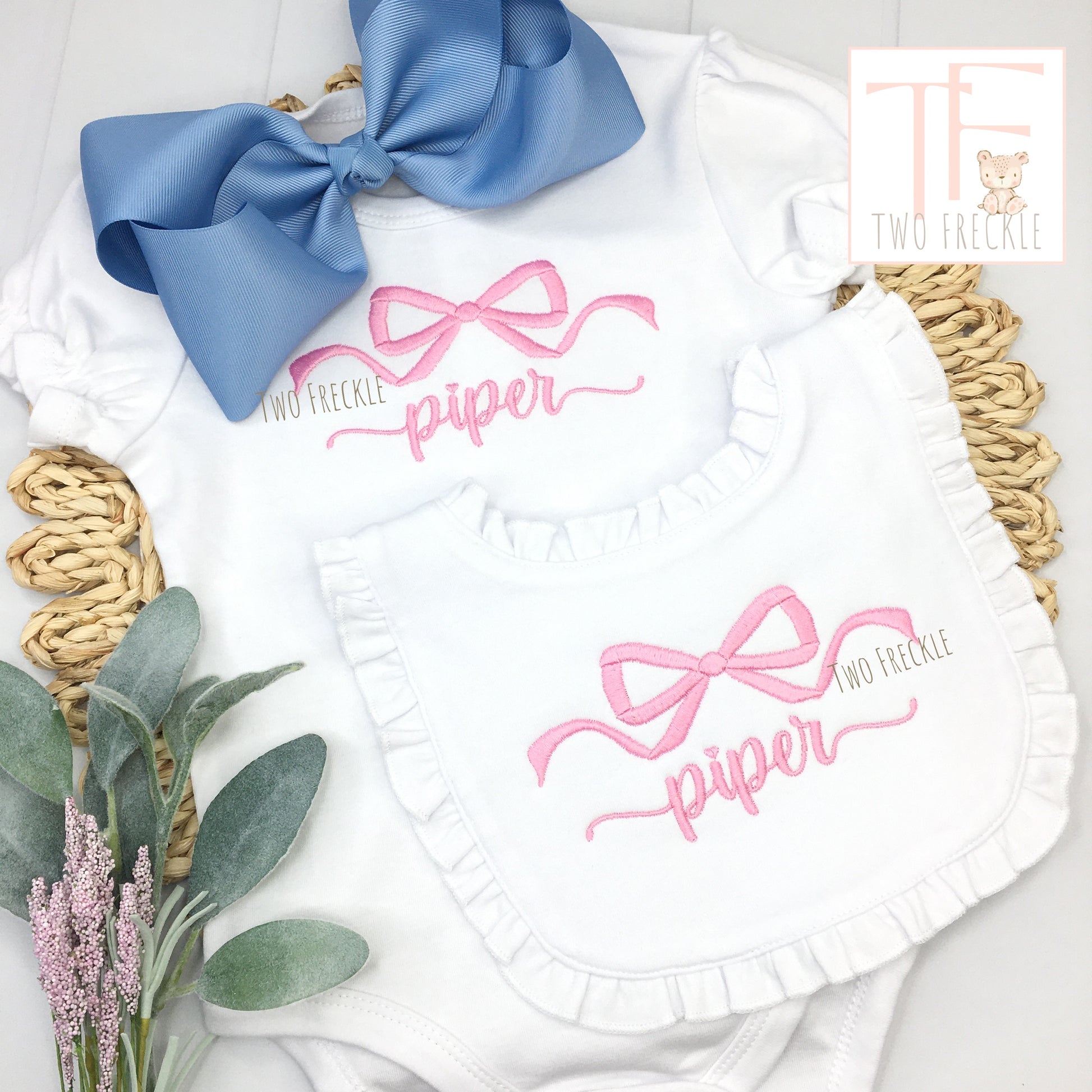 a baby girl's personalized bib and bib with a blue bow