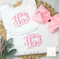 two personalized bibs and a pink bow